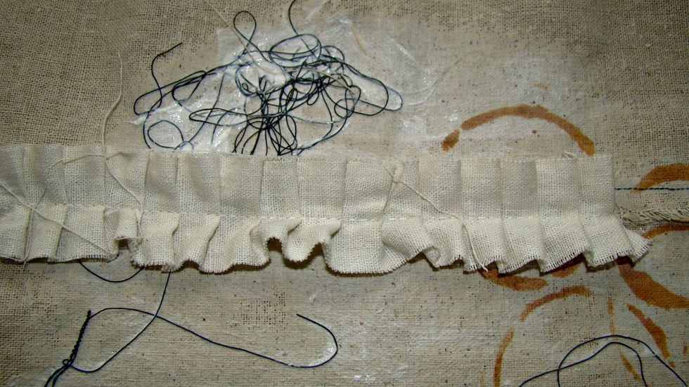 I took a piece of muslin and made a quick ruffle then glued different pieces here and there to the front of my main backdrop.