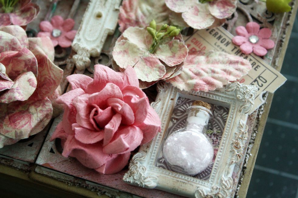 I took a small vial and put glitter glass in it, gluing the cap on. I then placed it inside in the resin frame