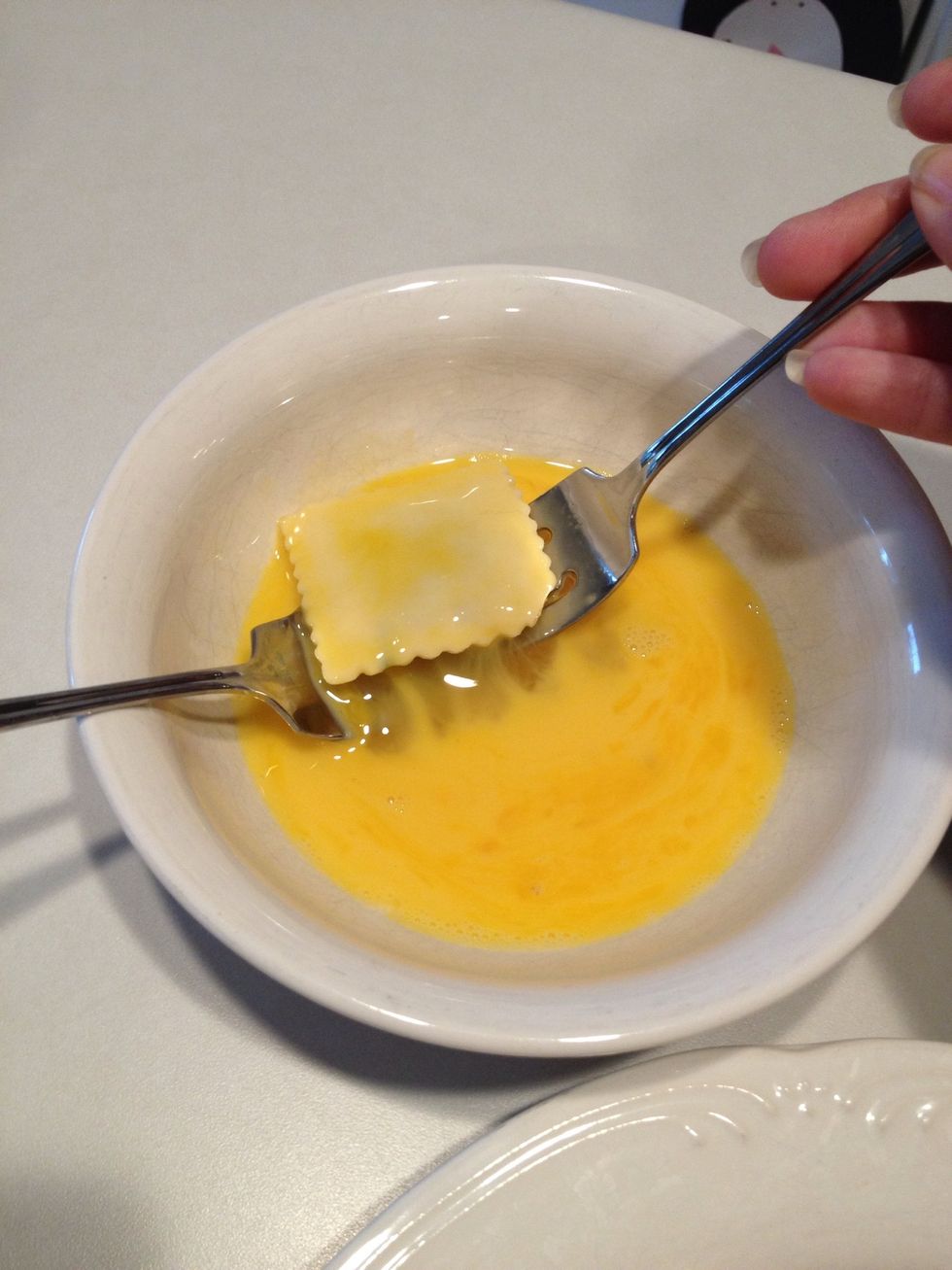 I use two forks to lift the ravioli out of the egg mixture.