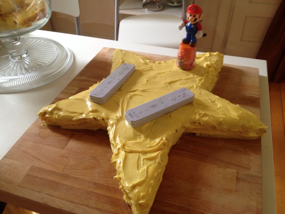 I used 2 boxed cake mixtures to make a large flat cake. I cut it into a shape and iced it with lemon icing. I added yellow food coloring to get the right yellow. I added candy tins from party city.