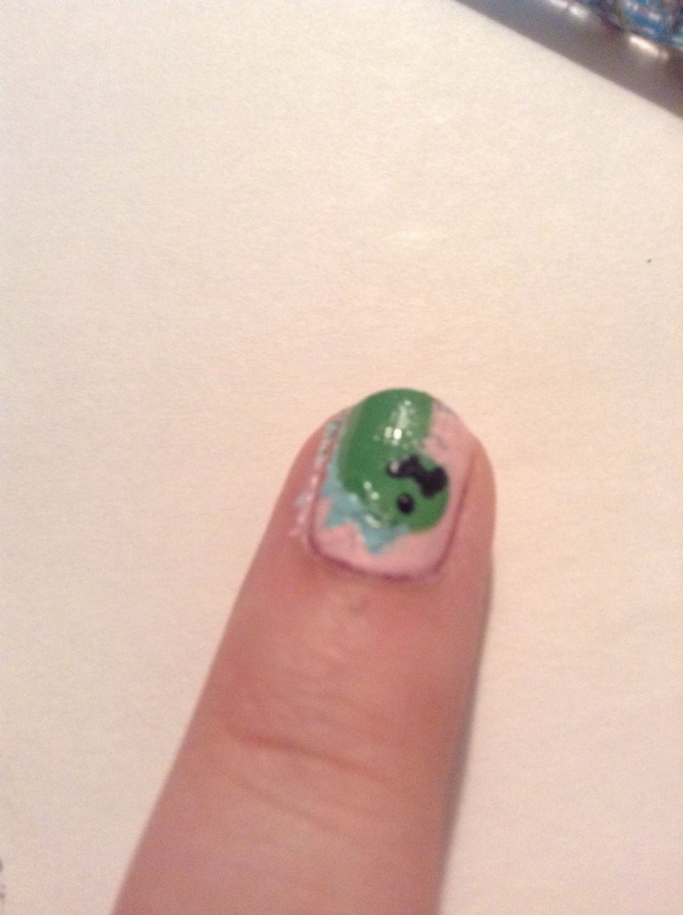 I used a black striper but you can use whatever you used for the spikes, to make an eye and a mouth. Clean up with polish remover and a small brush or q-tip. Then top coat, and you're done!