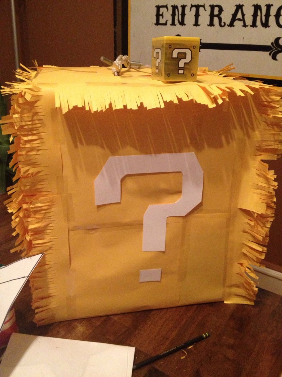 I used a large box, added lots of pi\u00f1ata candy and taped shut with two holes at the top for the pi\u00f1ata rope. I later used yellow construction paper to cover it and added a question mark like in Mario