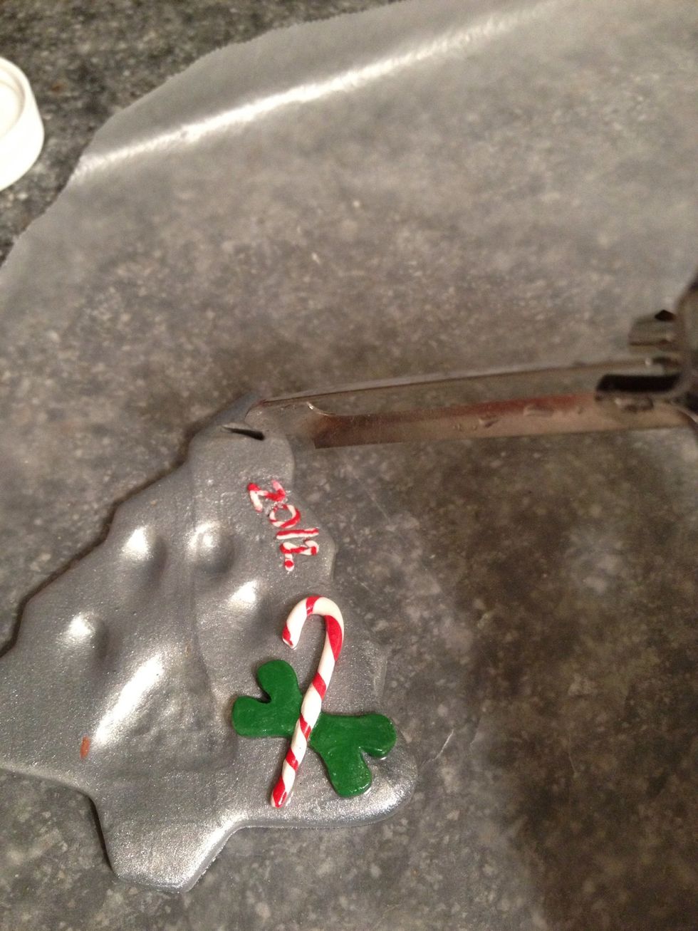 I used a potato peeler to create a hole for the ribbon. I also used left over candy cane twist to fill in the year.