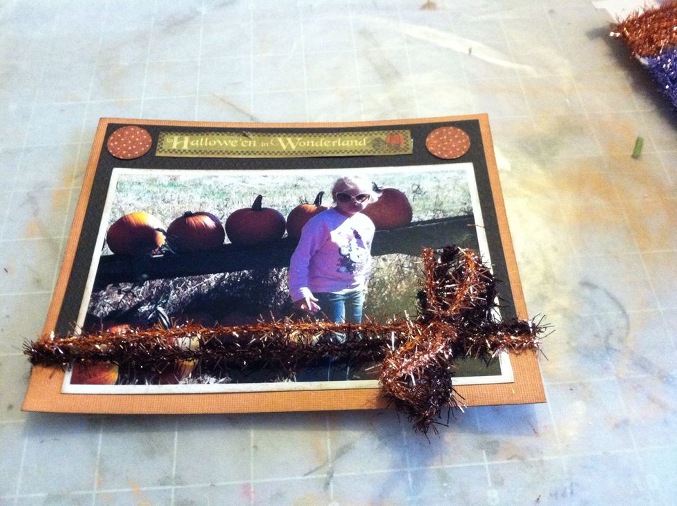 I used black and light orange card stock to mat the photo. Then I added pieces from the cut apart page of the collection. I tied two colors of tinsel twine around the bottom of the photo.