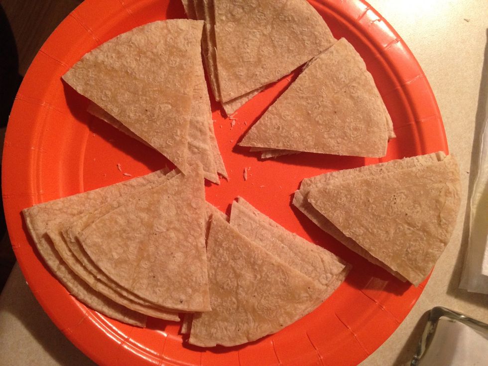 I used kitchen scissors, but you can just use a knife and cut four tortillas into 6 triangular pieces. After cutting them you should have 24 triangular pieces.