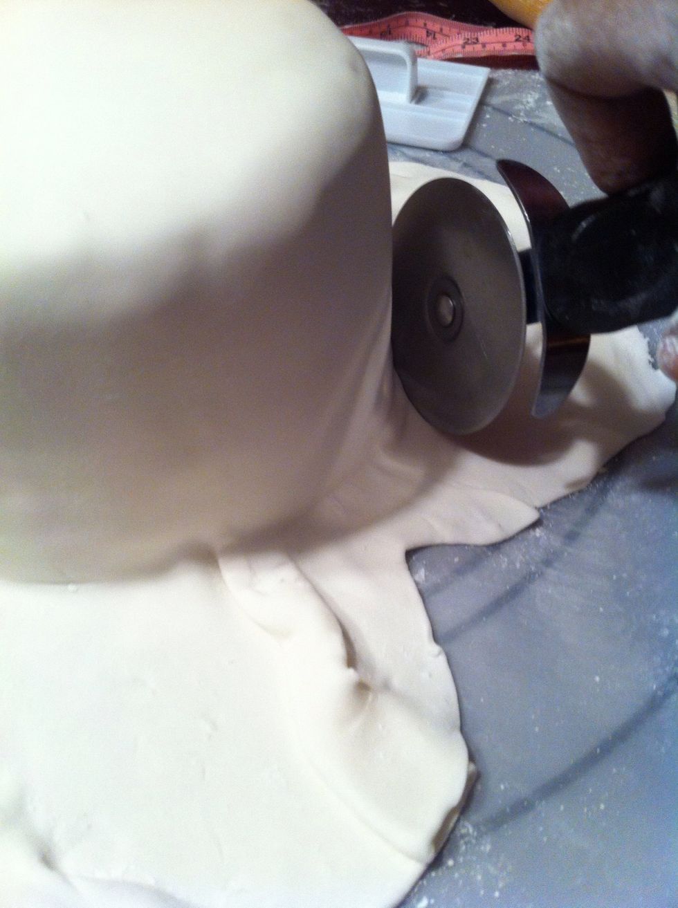 I used my hands to smooth the fondant (slowly) from top to bottom. Use a pizza cutter to cut off excess fondant & store the extra pieces in an air tight bag.