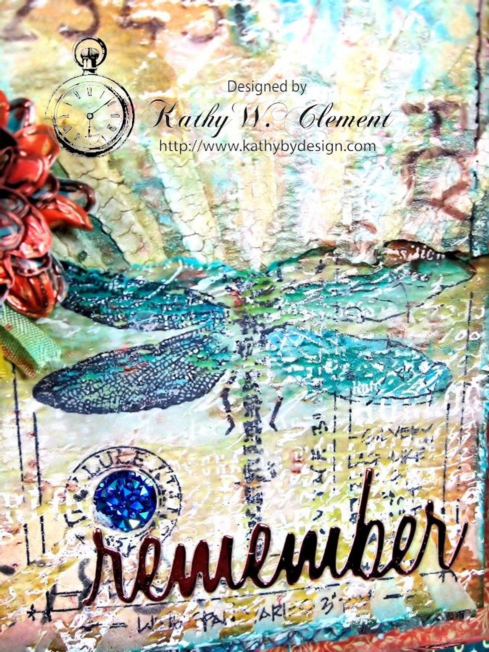 I used Ranger Jet Black Archival ink to stamp my dragonfly, then colored in the wings with Distress Re-inkers and a water brush. A sentiment was die cut from copper metallic paper & gems were added.