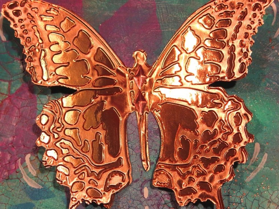 I used Tim Holtz's set of die and folder to cut this butterfly out of foil sheets. The wings are glue in the up-position after light sanding. I added diamonds to his body for subtle texture.