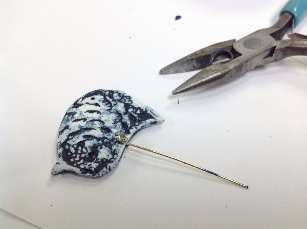 I've inserted the jewelry wire through the top hole of the bird and bent it upward.