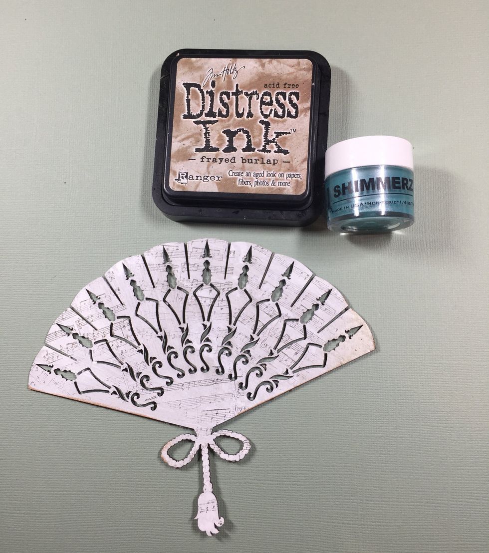 I want to give it a blue wash with this Shimmerz turquoise paint. Any sheer paint will do. Then, I will ink the edges with the distress ink.