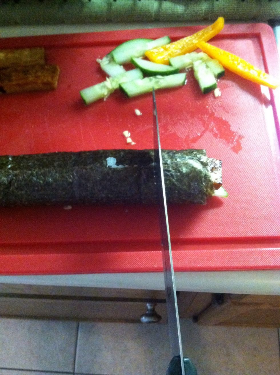 I wet my knife with hot water in between each cut to make it easier. Slide the knife, don't press down directly. Use your other hand to hold the roll.
