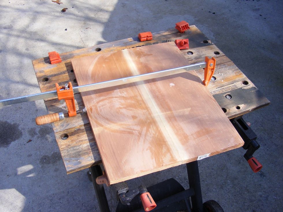 I will attach the hard hat to a 18 inch by 15 inch cedar board. This picture shows me glueing 2 boards together.