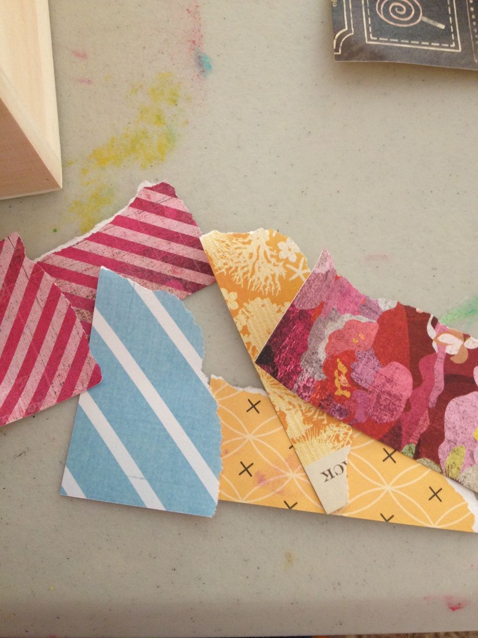 I will begin by tearing small random pieces of the patterned paper. Coat the back with mod podge and begin placing them randomly along the box.