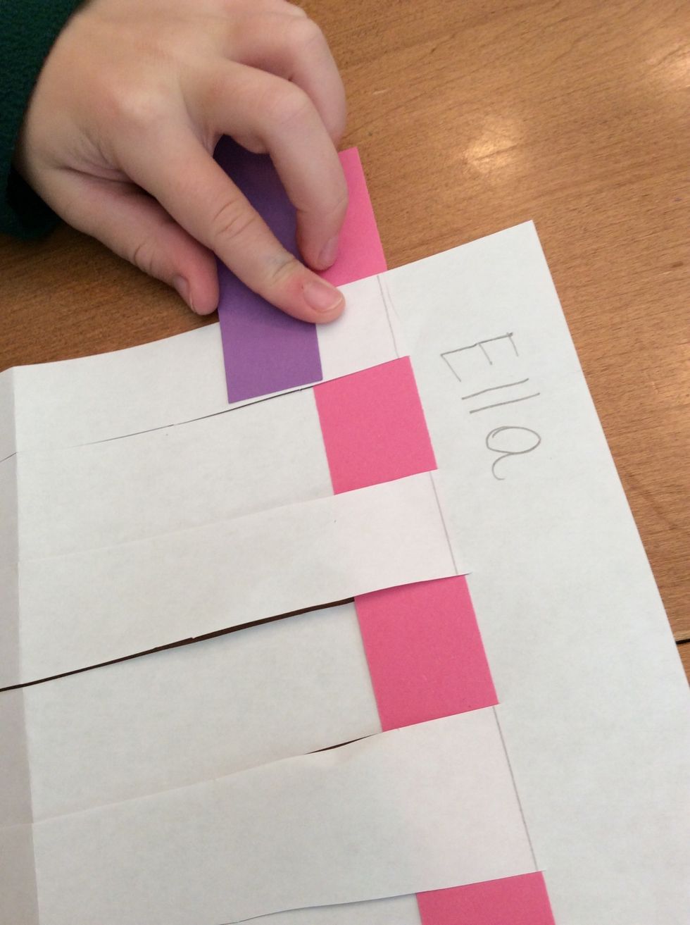 I will begin weaving my new strip OVER the paper because I know that the opposite of under is over. This will make my weaving strong.