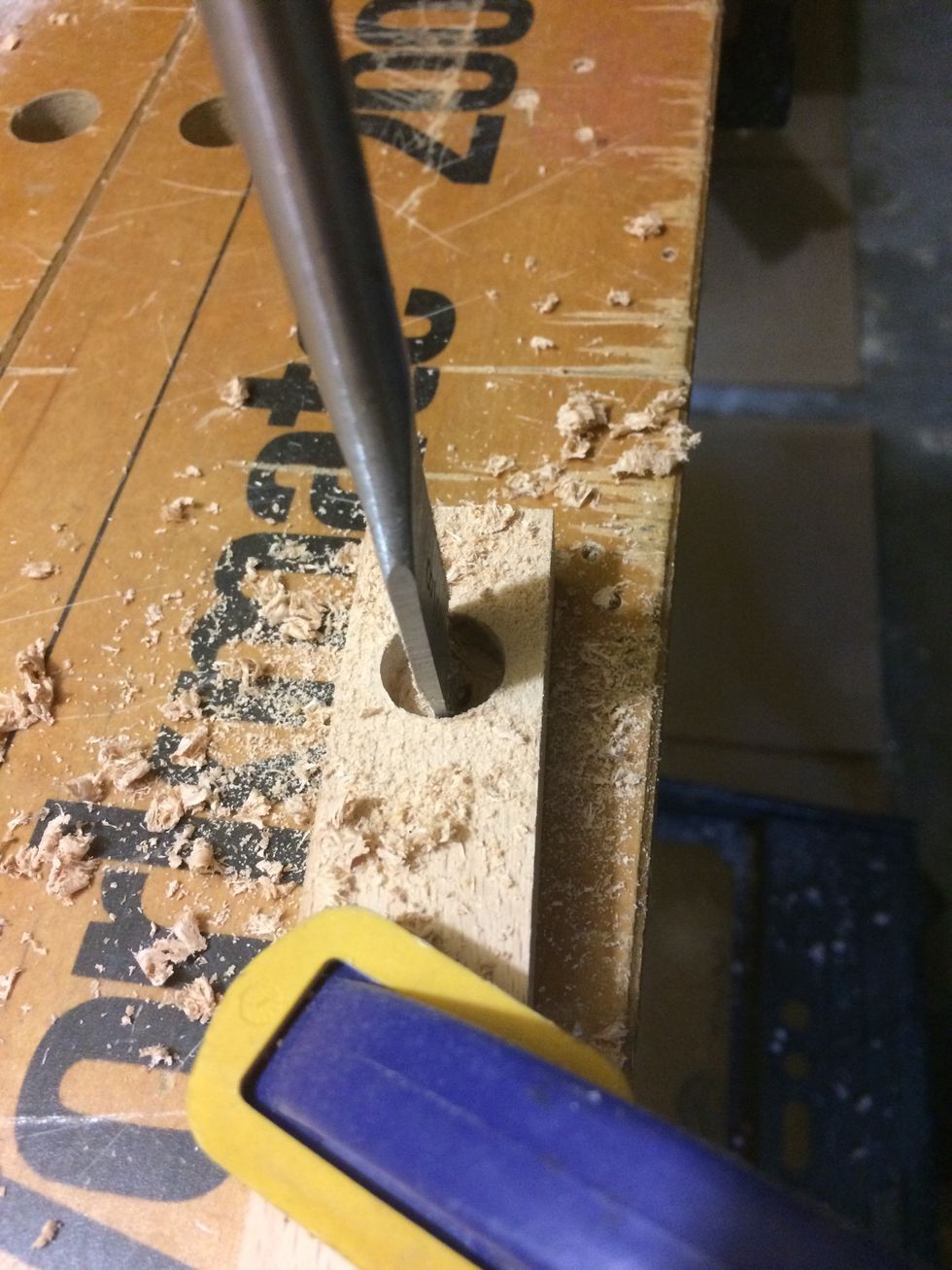 I would start drilling in one side until the tip came through the bottom. Then I would flip it over and drill this side until all the way through. I do this so I don't have tear out at the bottom.