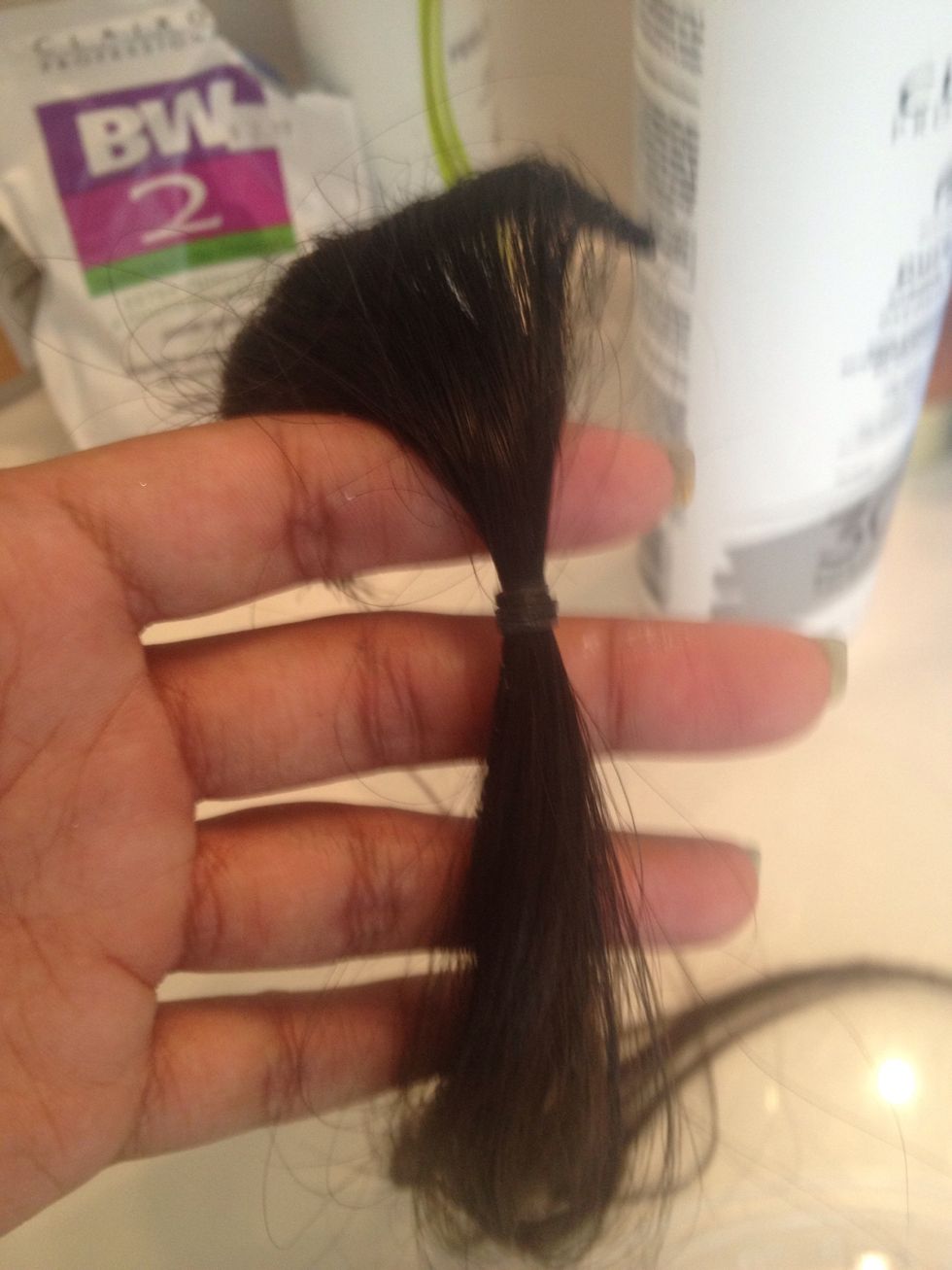 I wrapped a rubber band to separate the section where I want the bleach to go from the hair that will remain dark.
