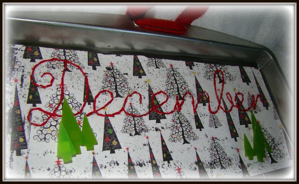 I wrote out my letters first then just followed them with the basic stitch using red embroidery floss on scrapbook paper. Adhered down to cookie sheet.