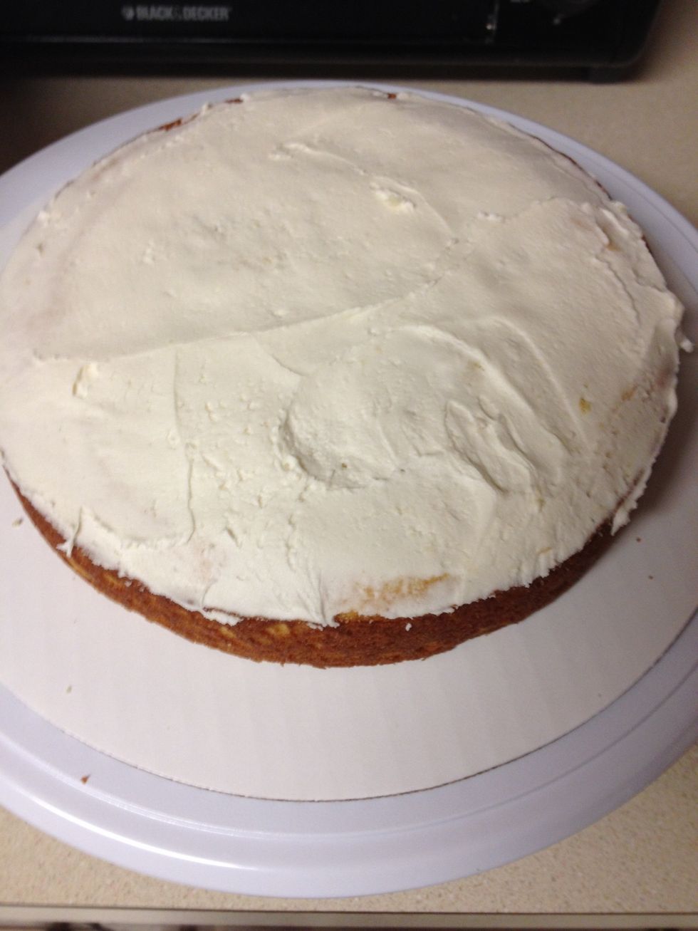 Ice the top of the first cake and then place the second layer on top