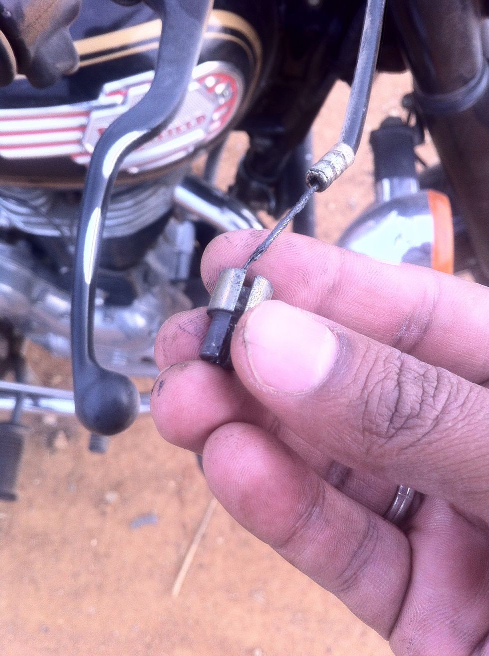 If it is on the throttle cable slide it out and keep safe. If you are doing a regular maintenance cable change, then pull down the cable and slide the adaptor out. Store in safe spot till reassembly.