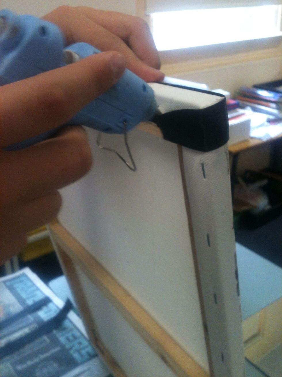 If there is any ribbon off the edges stick them behind the canvas like this