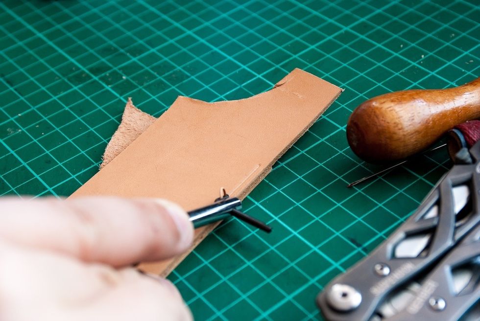 If you have a stitching groover, cut the groove. If you don't have one, mark the leather somehow (ruler or something that lets you control the distance to the edge of the leather & keep it consistent)