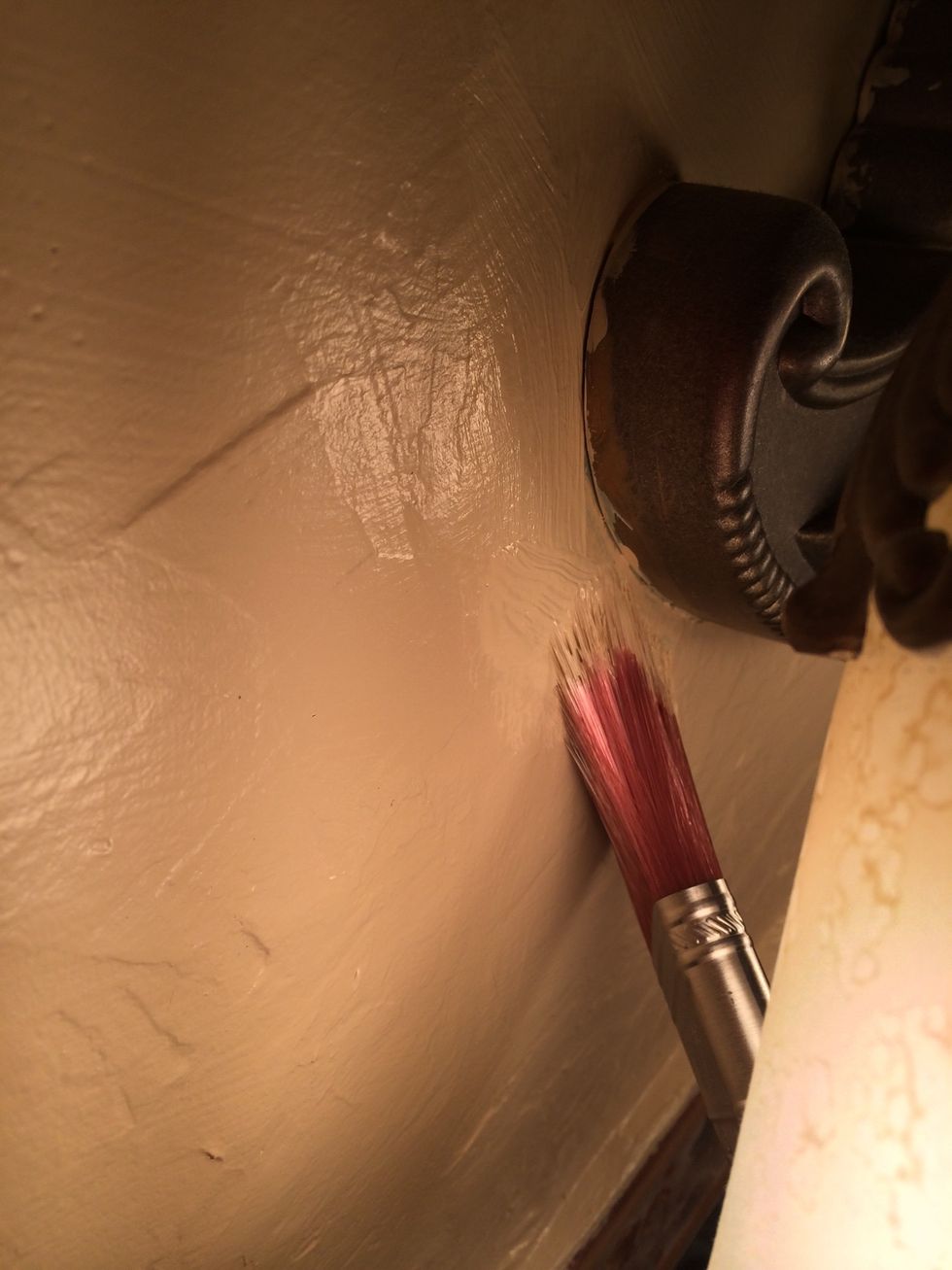 If you must use a brush, use an angled one and work slowly pulling the paint gently towards the spot you are trying to paint.