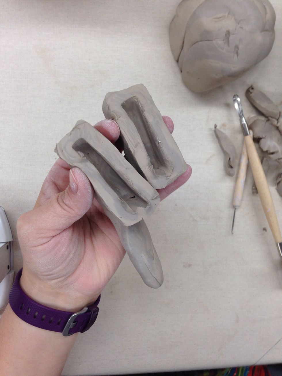 If you need to add support to the center, I some times use paper towels or any paper and roll it up and put it inside.  This will turn to ashes in the kiln.