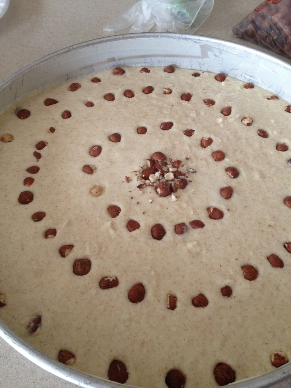 If you're using nuts, prepare them as garnish. I like crushed hazelnuts or peeled/halved almonds. You can arrange them or randomly place them wherever. Just make sure to "embed" them in the basbousa.