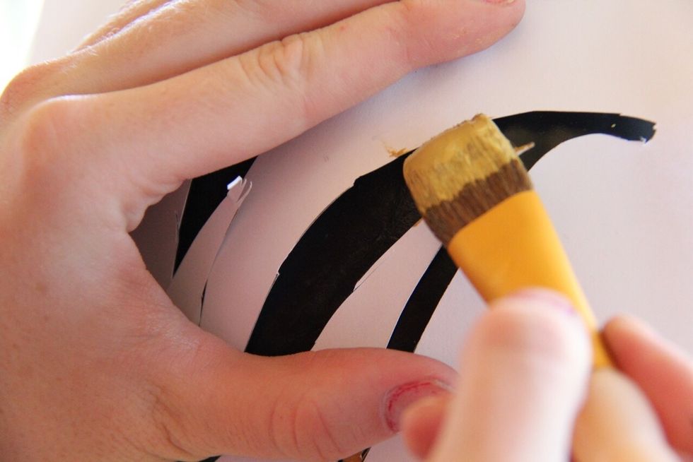 If you're using paint then grab your paint brush, hold up your letter stencil to the pumpkin, and fill in with gold paint. If you use gold spray paint, line up stencil and spray.