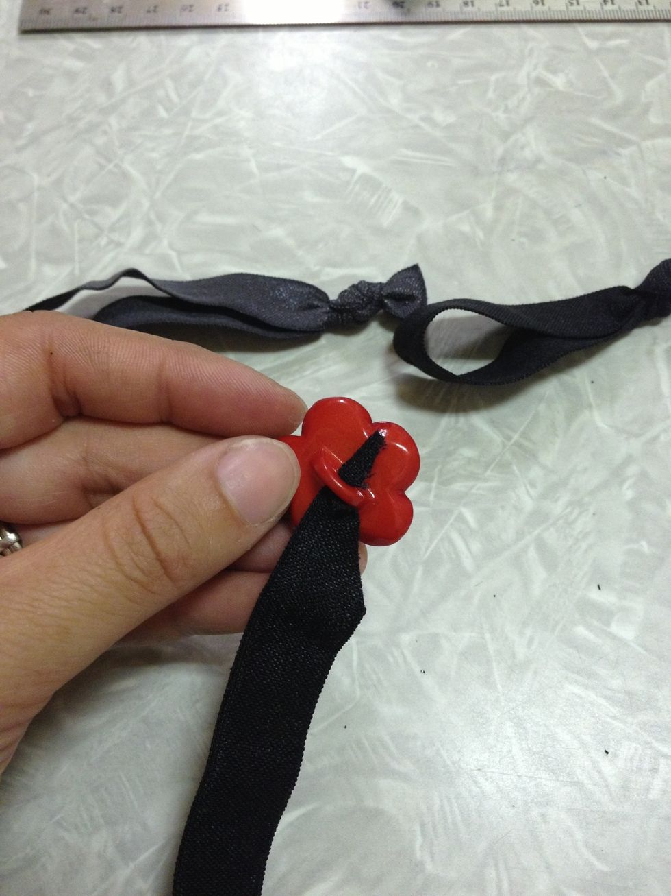 If you want to add buttons to embellish your hair tie, it is easiest to cut the elastic at an angle before you thread it through the hole.