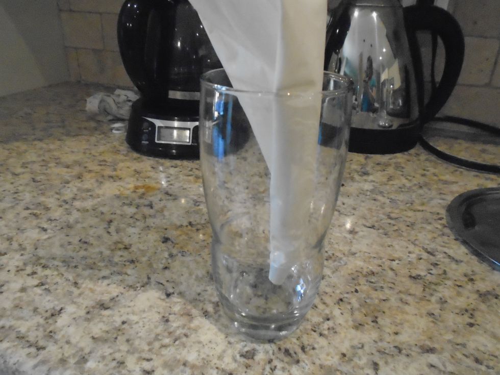 If you will be doing piping on the cake as decoration , this is what i do to get the frosting in the bag easier.  Place bag tip side down in a tall glass.