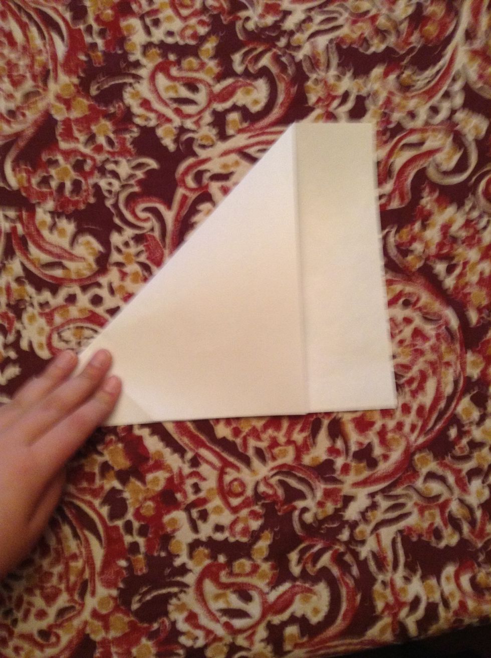 If your paper is a square already skip this step. Position this paper horizontally. Fold the top left corner to the bottom edge like shown. Then you can either cut the small rectangle or detach it.