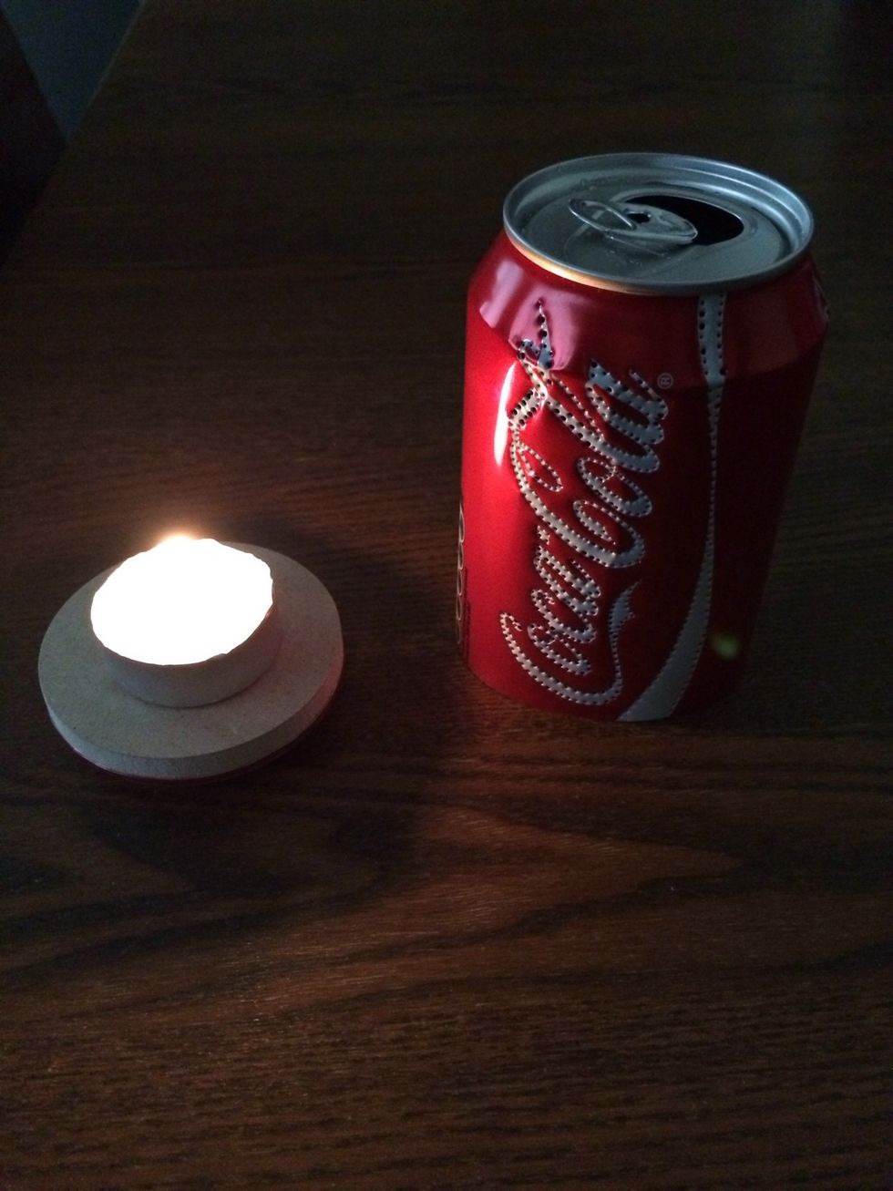 Ignite the tea light.  The MDF could be drilled to accommodate the tea light but I did not have the correct diameter bit!  Provided you are sensible when moving the can, the light won't move too much.