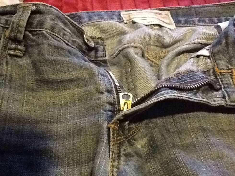 Imagine that the pull of tour zipper is a key, just insert the ring through it.