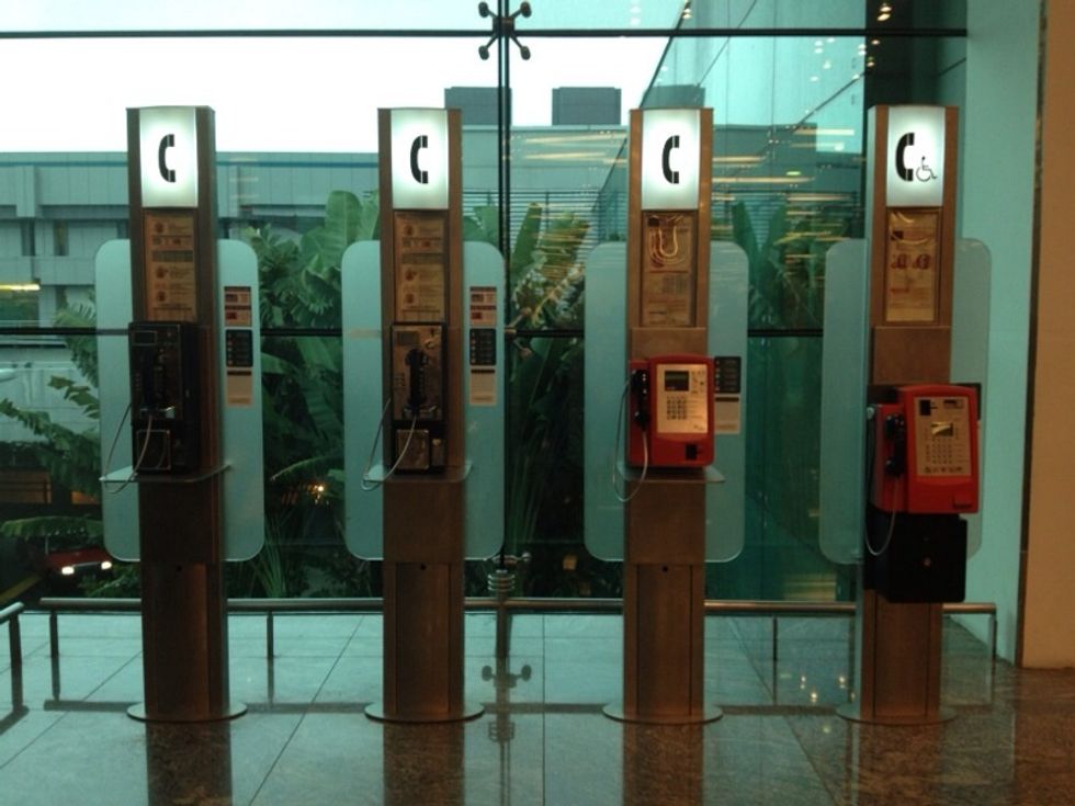 Immediately after the escalator, you will see a row of telephone boxes where you can put in 10 cents and make a few minute call to local numbers