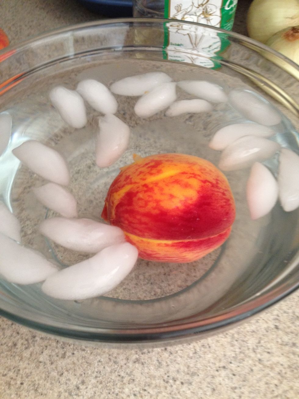 ...immediately place each peach into an ice bath...let it sit in cold water for about 20 seconds. Then take the fruit out of the water...