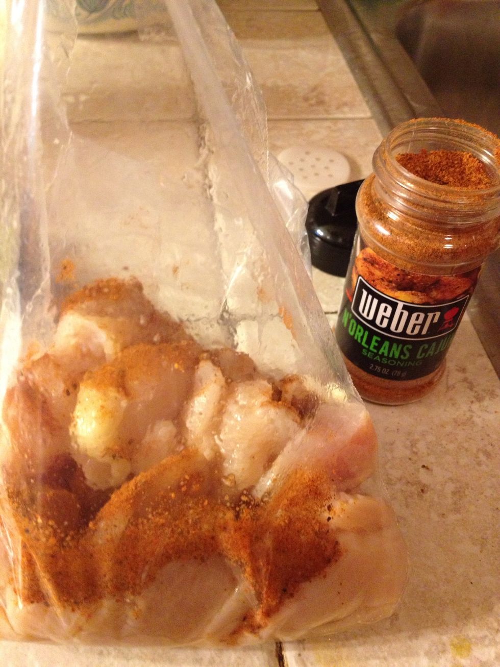 In a bag, toss around the chicken and the Cajun seasoning