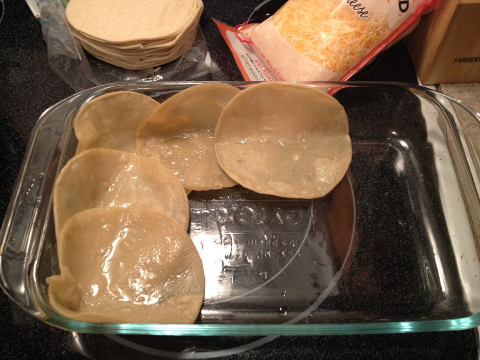 In a baking dish, layer the bottom with your lightly fried corn tortillas.