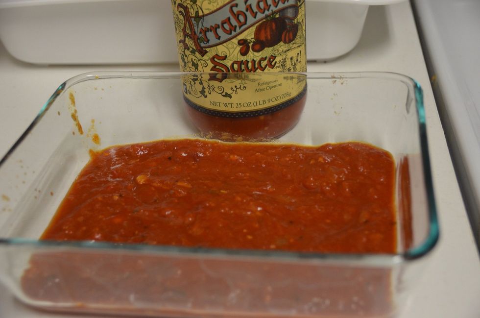 In a baking dish spread some arrabiata sauce. ( any store bought sauce is good. Here I have used trader joes arrabiata sauce)
