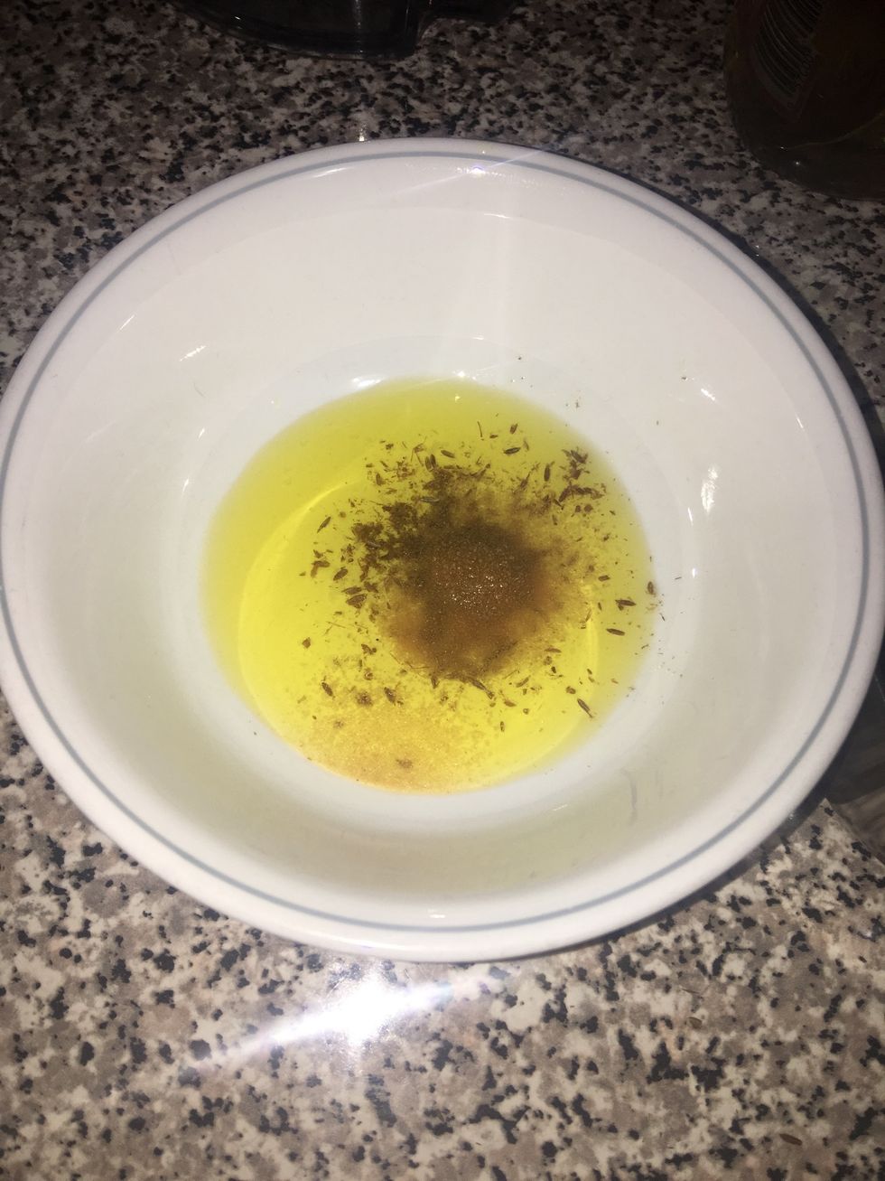 In a bowl, add the ingredients: 3 tablespoons of canola oil, 3/4 teaspoons of cumin, 1/4 teaspoon of garlic powder and a pinch of salt.