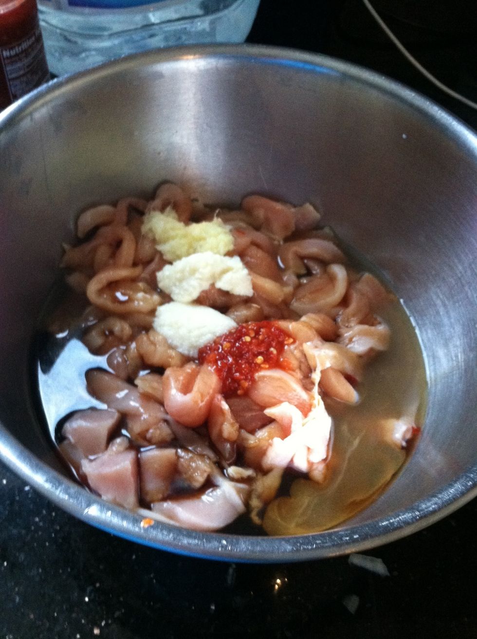 In a bowl, marinate the chicken with soy sauce, ginger and garlic paste, lemon juice, and chili garlic paste