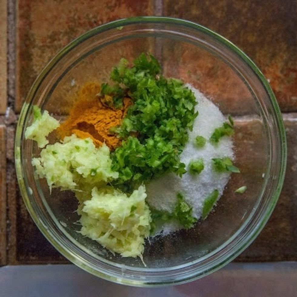 In a bowl mix together the turmeric, ginger paste, shallot or garlic paste, serrano chilies, salt, sugar andajwain seed. Set it aside.