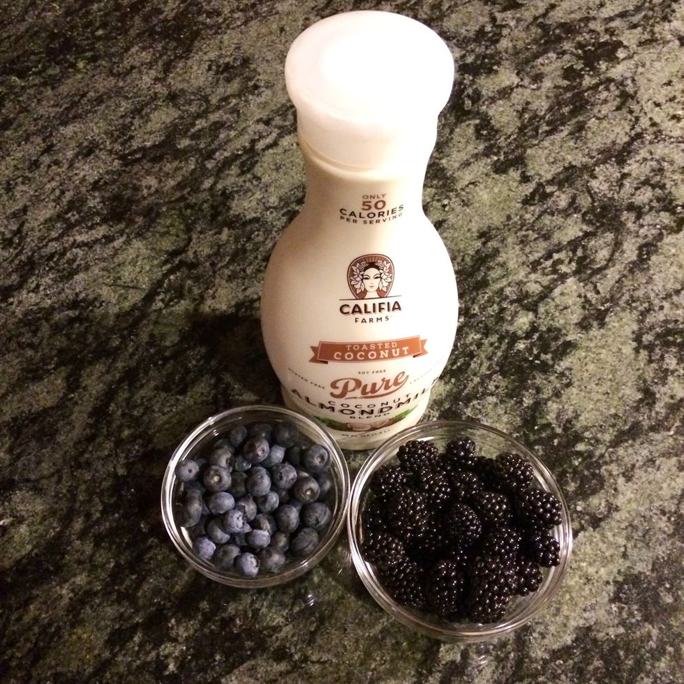 In a clean blender, add a half cup Califia coconut almond milk blend, a cup blueberries and a cup blackberries.