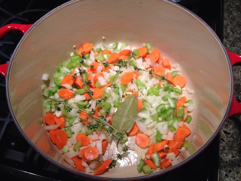 In a fresh soup pot, heat olive oil over medium heat. Add vegetables, thyme and bay leaf. Cook until soft, but not browned, about 6 minutes.