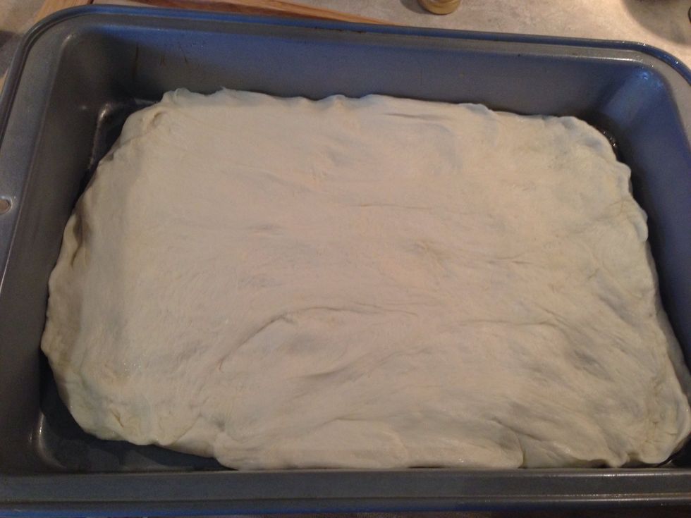 In a greased baking dish spread the dough evenly. Cover with that towel again for an hour.