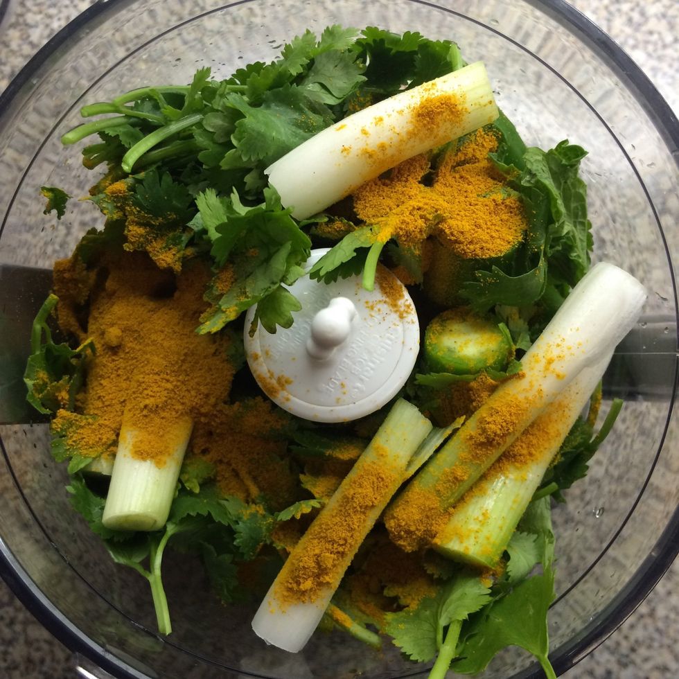 In a grinder, add 2 tablespoons of garlic olive oil, cilantro, serrano peppers, green onions, mint leaves and ground turmeric. Grind fine.