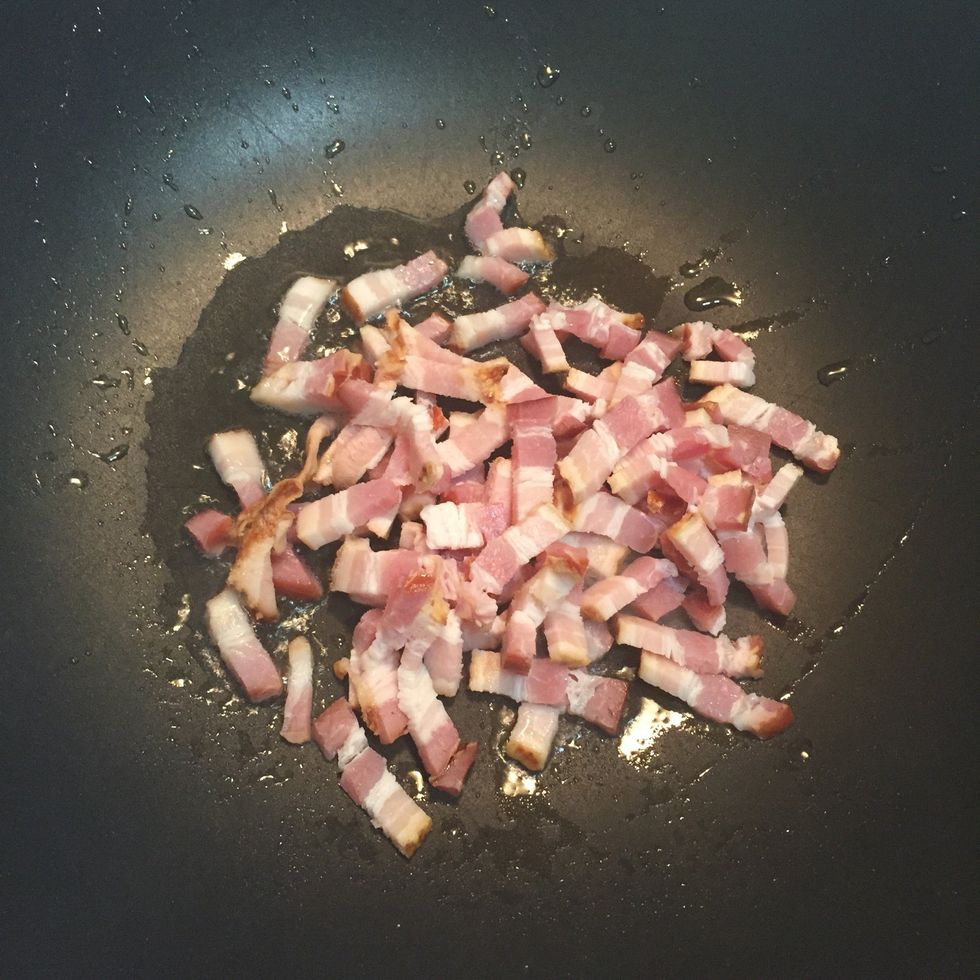 In a heated pot, add oil and stir fry bacon pieces.