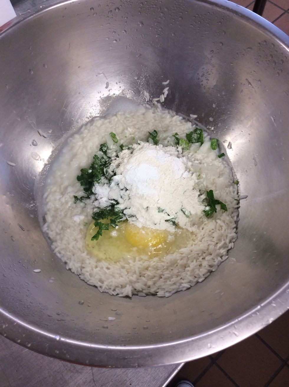 In a large bowl,mix the rice with the milk,egg,onion,green onion,parsley,baking powder,flour,& 1 teaspoon salt.add more flour if necessary