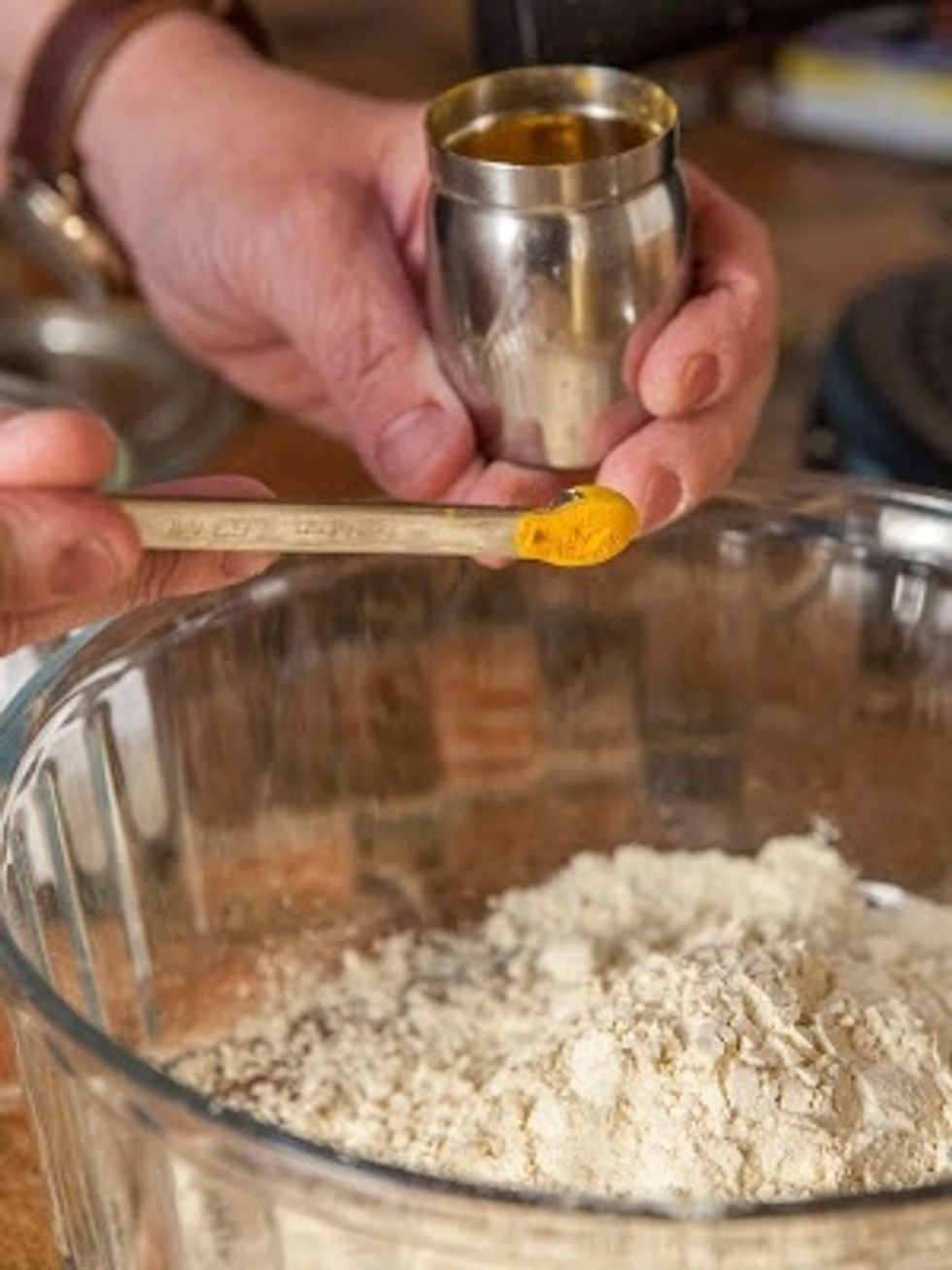 In a large microwave-safe bowl mix together the besan flour, the asafoetida, and the turmeric.