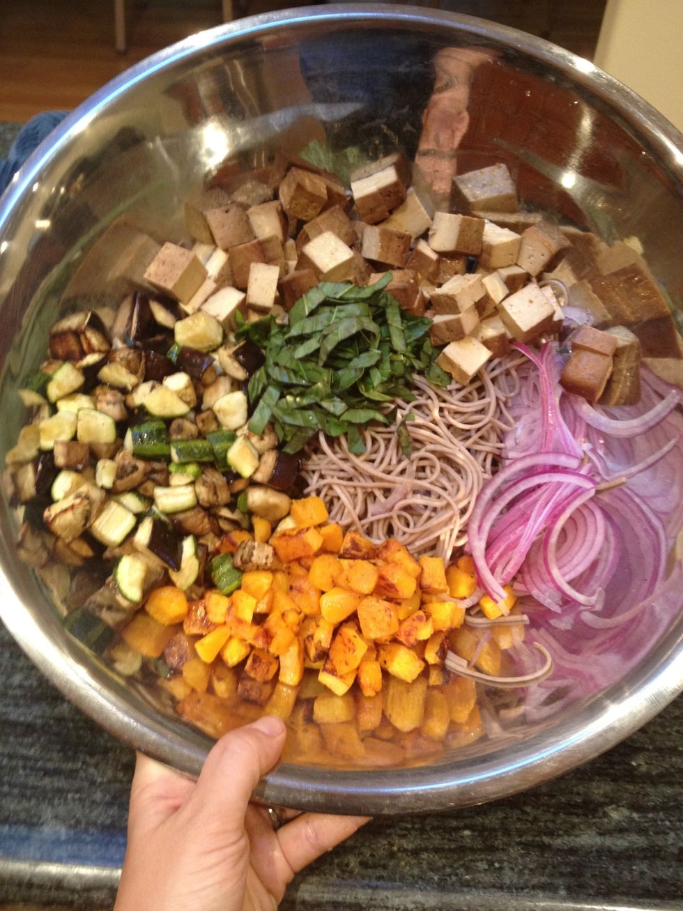 In a large mixing bowl, place the noodles, roasted vegetables, sliced onion, basil, and tofu.